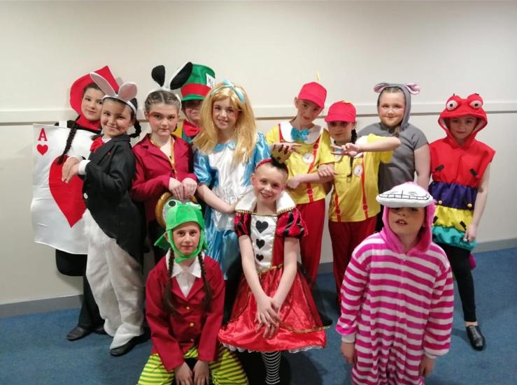 Acro students performing handstands on stage